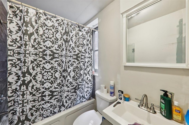 full bathroom featuring sink, shower / bathtub combination with curtain, and toilet