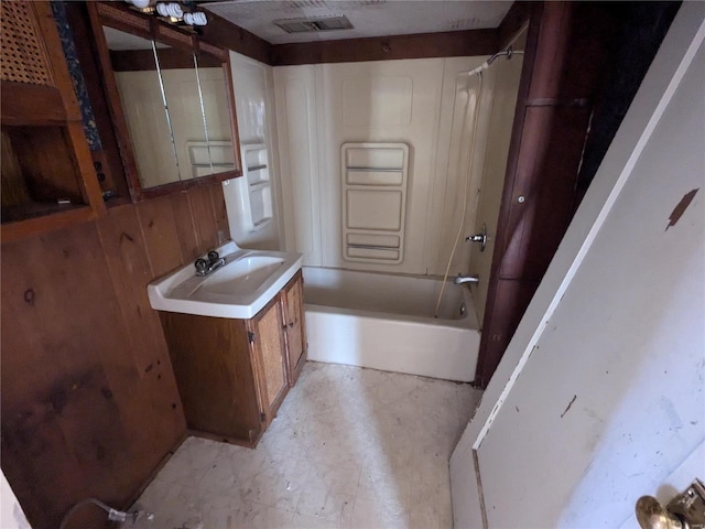 bathroom with vanity, shower / washtub combination, and wood walls