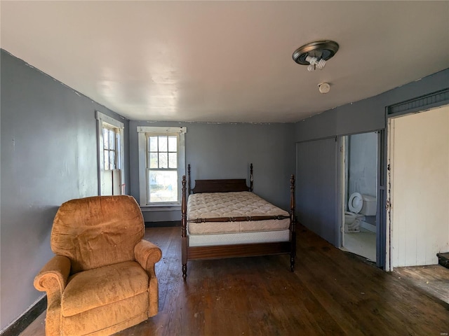 bedroom featuring dark hardwood / wood-style floors and ensuite bath