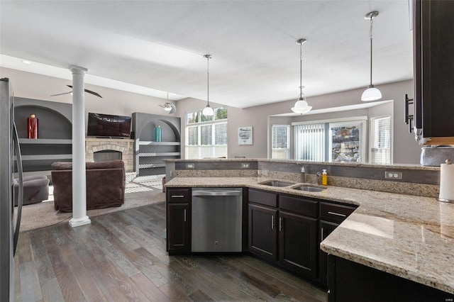 kitchen featuring light stone countertops, sink, stainless steel appliances, dark hardwood / wood-style floors, and decorative light fixtures