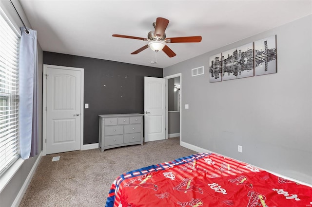 carpeted bedroom with multiple windows and ceiling fan