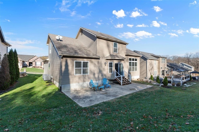 rear view of house with a lawn, a patio, and central AC