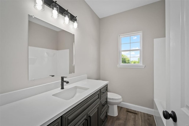 full bathroom with hardwood / wood-style floors, vanity, shower / bathtub combination, and toilet