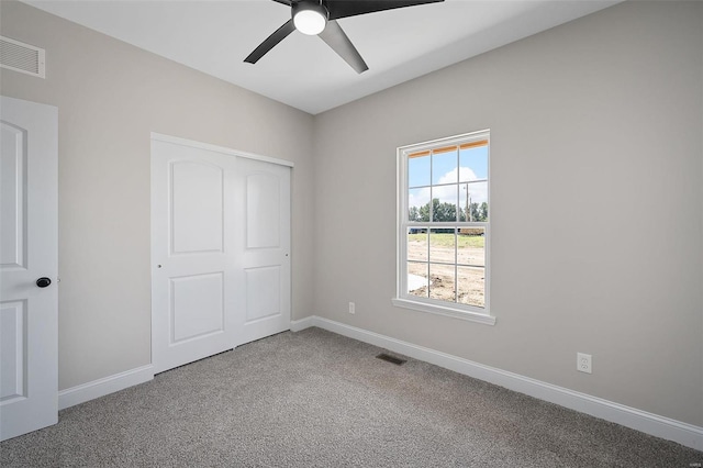 unfurnished bedroom featuring ceiling fan, a closet, and carpet floors