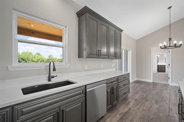 kitchen with sink, an inviting chandelier, stainless steel dishwasher, hardwood / wood-style floors, and lofted ceiling