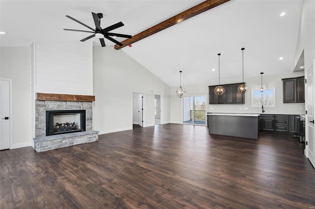 unfurnished living room featuring beamed ceiling, high vaulted ceiling, dark hardwood / wood-style floors, and a stone fireplace