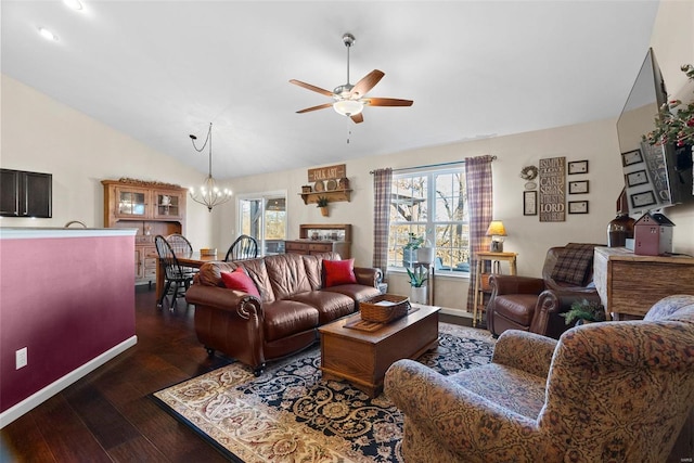 living room with ceiling fan with notable chandelier, dark wood-type flooring, and vaulted ceiling