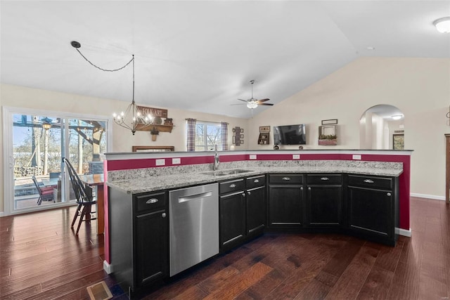 kitchen featuring a center island with sink, lofted ceiling, hanging light fixtures, stainless steel dishwasher, and sink