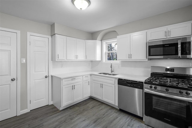 kitchen featuring hardwood / wood-style floors, white cabinetry, sink, and stainless steel appliances