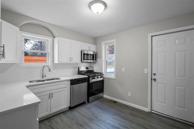 kitchen with white cabinets, appliances with stainless steel finishes, plenty of natural light, and sink