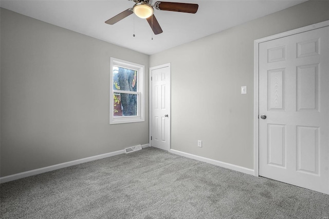 carpeted spare room featuring ceiling fan