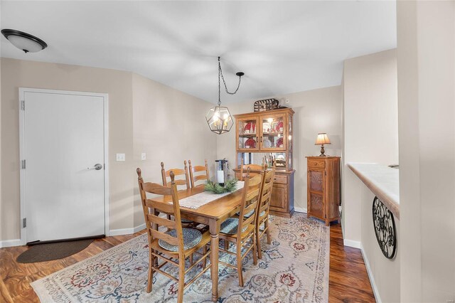 dining space featuring dark hardwood / wood-style flooring and an inviting chandelier