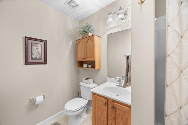 bathroom with tile patterned flooring, vanity, and toilet