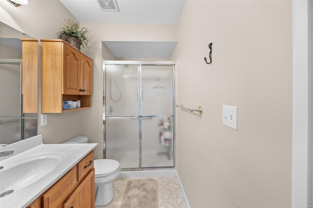 bathroom with vanity, toilet, and a shower with shower door