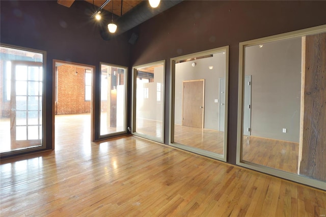 unfurnished room with lofted ceiling and light wood-type flooring