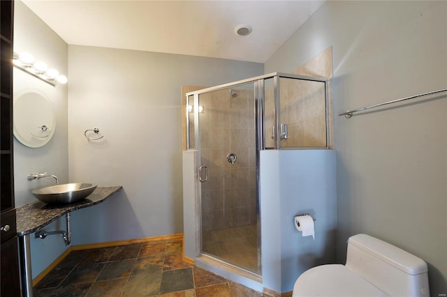 bathroom featuring lofted ceiling, toilet, a shower with shower door, and sink