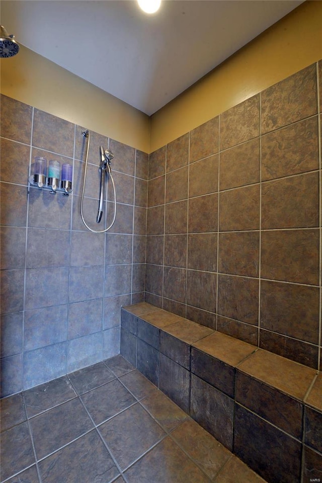 bathroom featuring tiled shower and tile patterned flooring