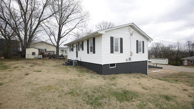 view of home's exterior with central AC and a lawn