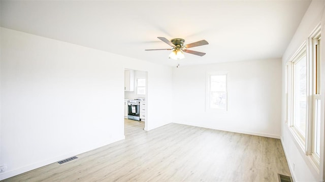 unfurnished room featuring ceiling fan, light hardwood / wood-style flooring, and plenty of natural light