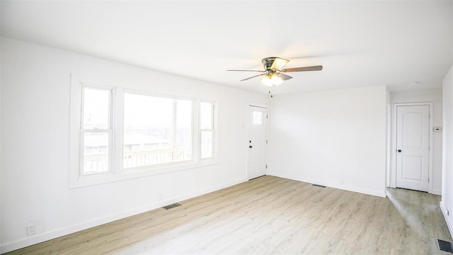 spare room featuring a wealth of natural light, light hardwood / wood-style flooring, and ceiling fan