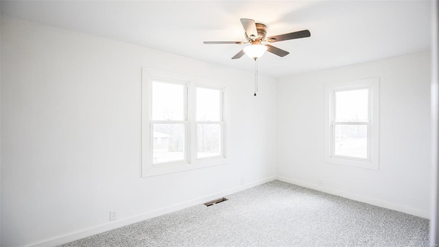 carpeted empty room featuring ceiling fan and plenty of natural light