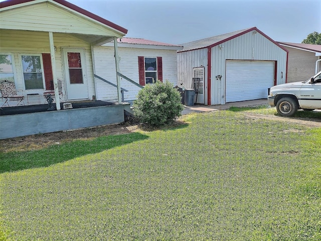 view of front of house featuring an outdoor structure, a front yard, and a garage