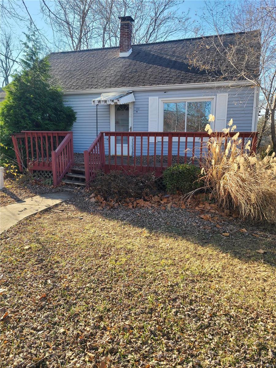 rear view of property with a lawn and a deck