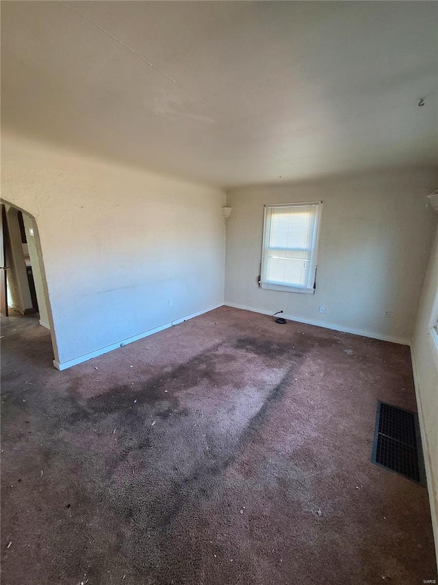 unfurnished room featuring dark colored carpet