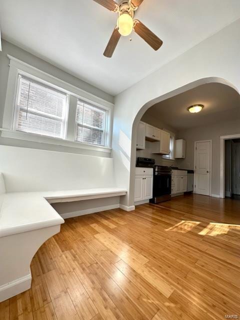 unfurnished living room with a wealth of natural light, light hardwood / wood-style flooring, and ceiling fan