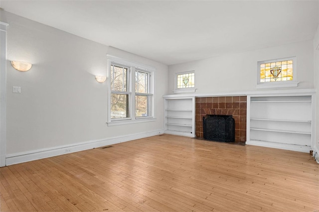 unfurnished living room with a fireplace and light hardwood / wood-style flooring