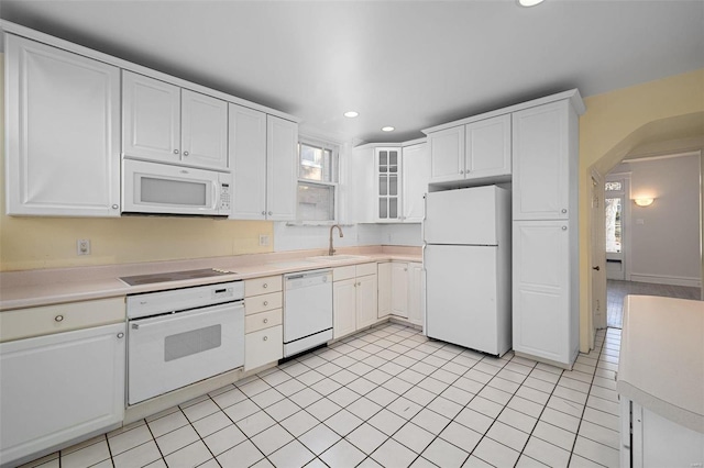 kitchen with white cabinetry, white appliances, and sink