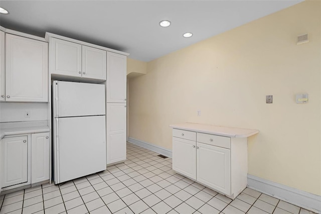 kitchen with white cabinetry, light tile patterned flooring, and white refrigerator