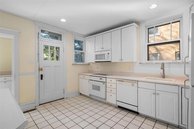 kitchen featuring sink, white cabinets, and white appliances