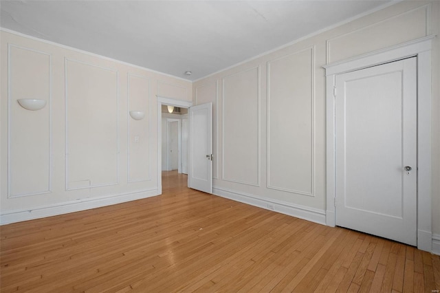 unfurnished bedroom featuring ornamental molding and light hardwood / wood-style floors