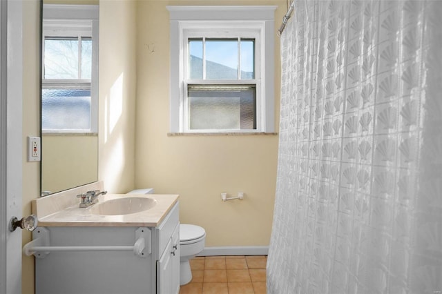 bathroom with tile patterned flooring, vanity, plenty of natural light, and toilet