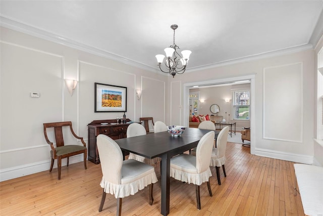 dining room featuring baseboards, light wood-style floors, ornamental molding, and an inviting chandelier