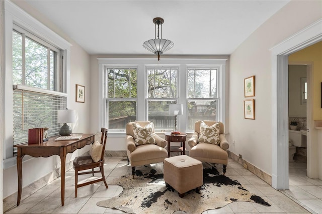 living area with baseboards and light tile patterned floors