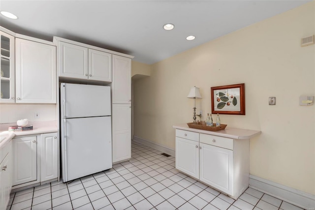 kitchen with freestanding refrigerator, white cabinets, light countertops, and visible vents