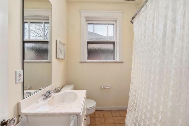 full bath with plenty of natural light, tile patterned floors, toilet, and vanity