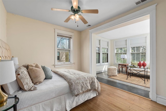 bedroom featuring visible vents, a ceiling fan, and wood-type flooring