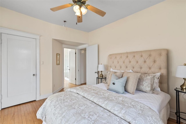 bedroom with a ceiling fan, baseboards, and light wood finished floors