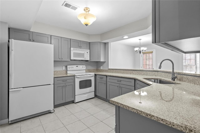 kitchen featuring pendant lighting, white appliances, sink, gray cabinets, and kitchen peninsula