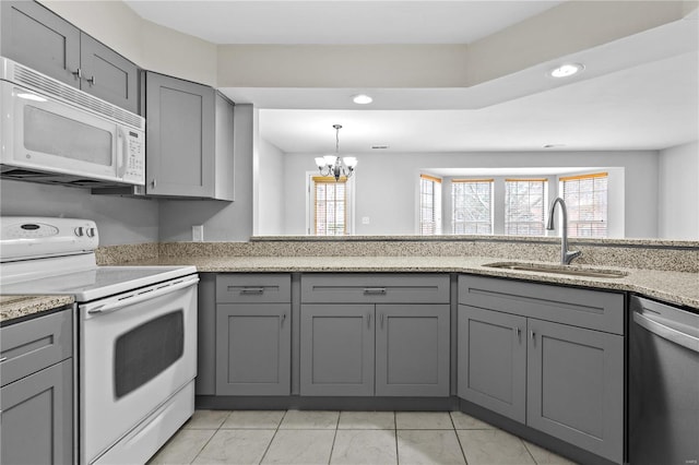 kitchen with white appliances, gray cabinets, a notable chandelier, and sink