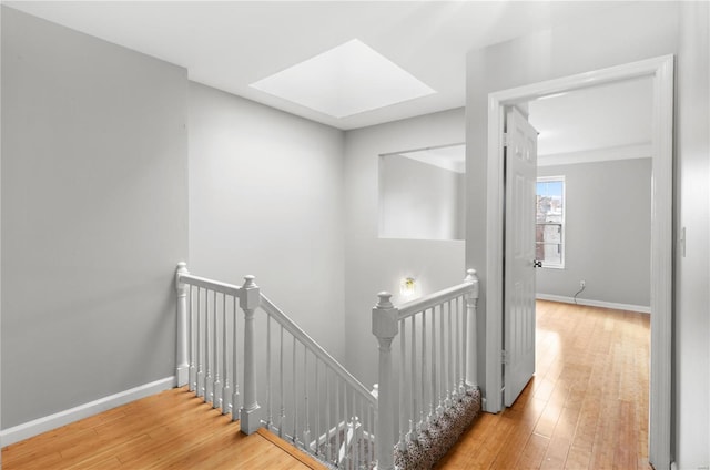 hallway featuring a skylight and hardwood / wood-style flooring