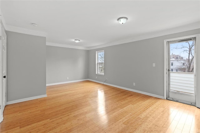 empty room with ornamental molding, light hardwood / wood-style flooring, and a healthy amount of sunlight