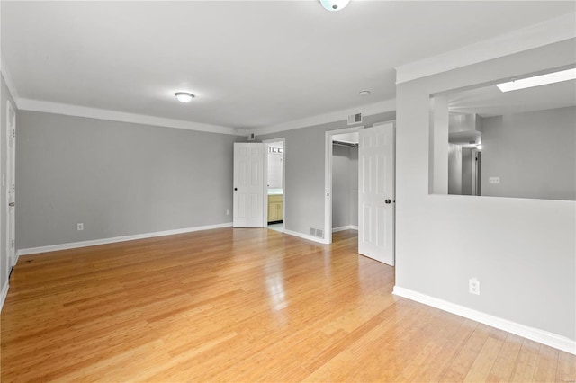 unfurnished room featuring crown molding and light wood-type flooring