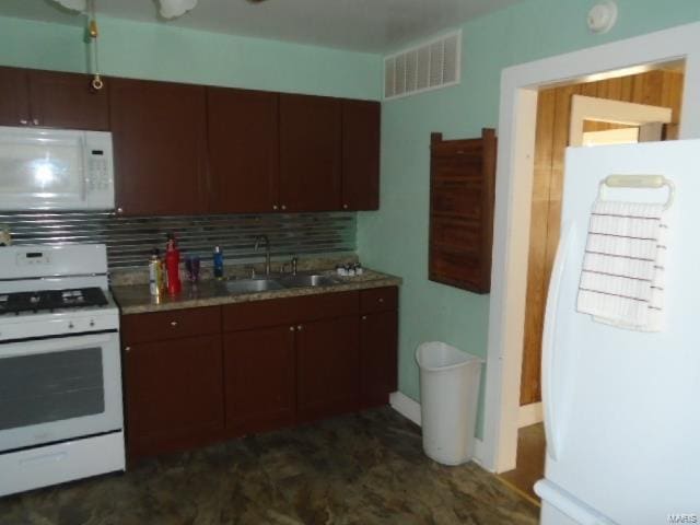 kitchen with decorative backsplash, white appliances, and sink