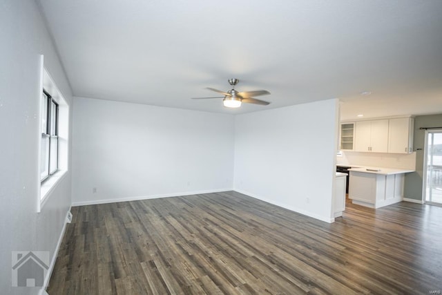 unfurnished living room featuring ceiling fan and dark hardwood / wood-style floors