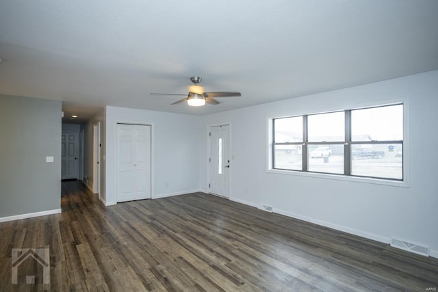 unfurnished living room with dark hardwood / wood-style flooring and ceiling fan