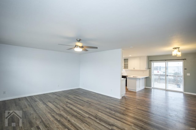 unfurnished living room with dark hardwood / wood-style flooring and ceiling fan